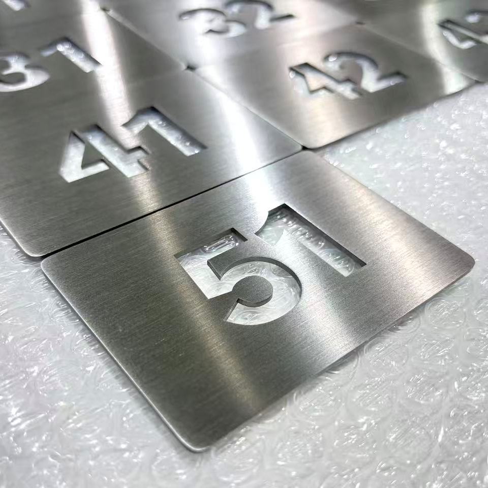 Plaques numérotées en inox brossé découpé pour signalétique d’hôtel