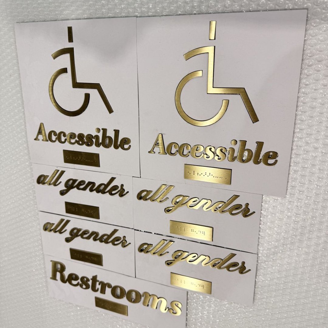 Plaques PMR accessibles avec pictogramme doré et braille